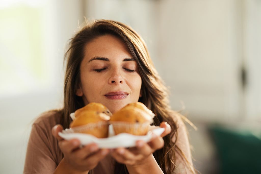 woman smelling muffins