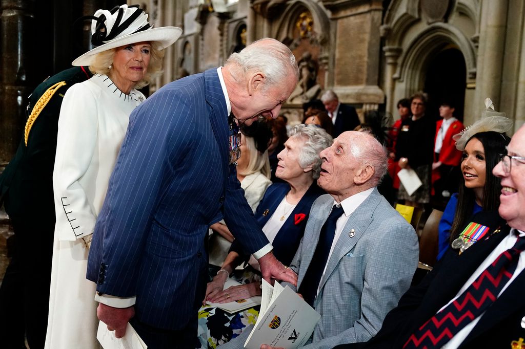 Queen Camilla and Britain's King Charles III speak to veterans 