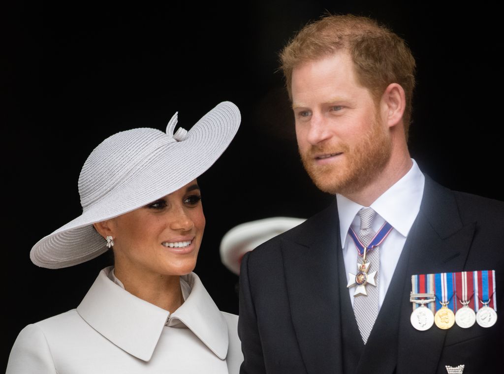 Meghan Markle in white and Prince Harry in a suit