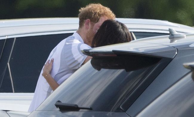 obscured by a car we see the back of a dark haired womans head and a red haired man kissing