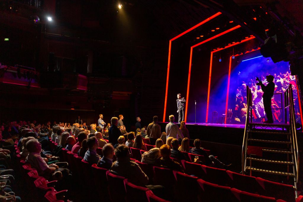 man on stage in theatre doing magic trick