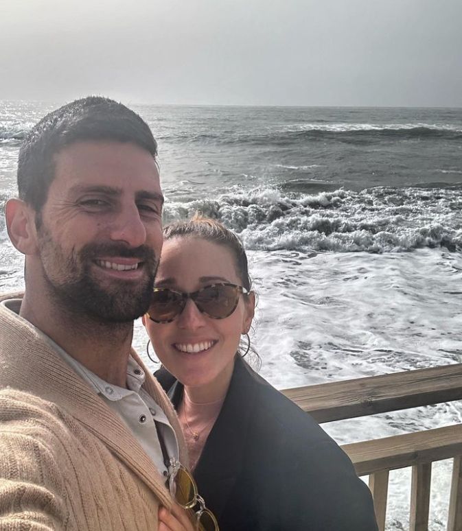 Novak Djokovic and Jelena Djokociv posing for a selfie with the sea in the background