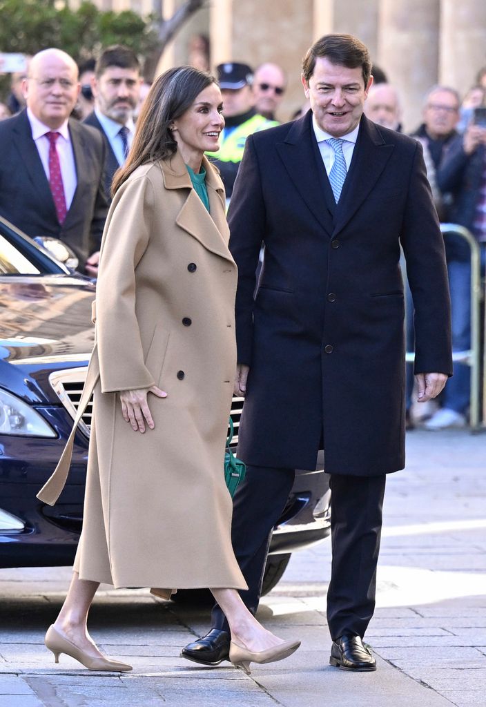 Queen Letizia walking next to man  in camel coat