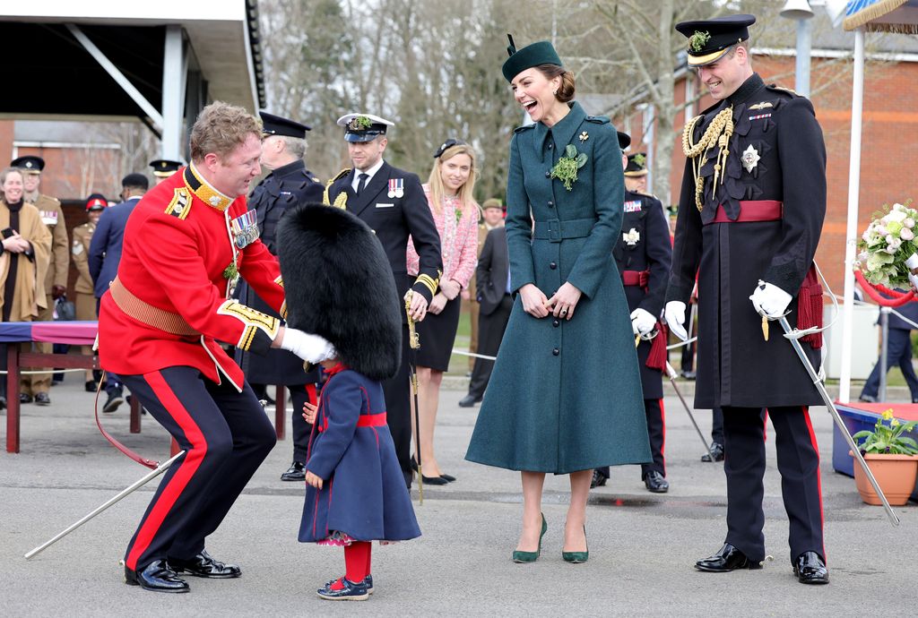 Kate and William laughing at Irish Guard putting bearskin hat on daughter