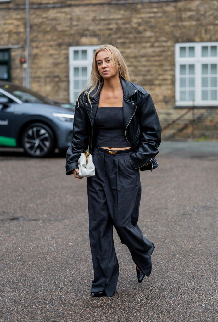 Sandra Hagelstam wore a black leather jacket with black wide leg trousers, a white bag and Prada shoes outside 7 Days Active during the Copenhagen Fashion Week Spring/Summer 2024