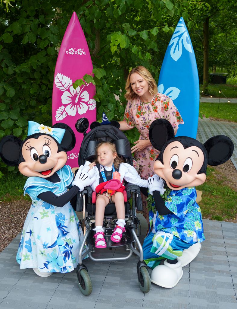 Kimberley Walsh poses with a little girl and Disney's Minnie Mouse and Mickey Mouse