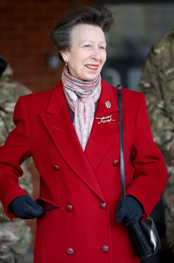 Princess Anne smiling and wearing red jacket
