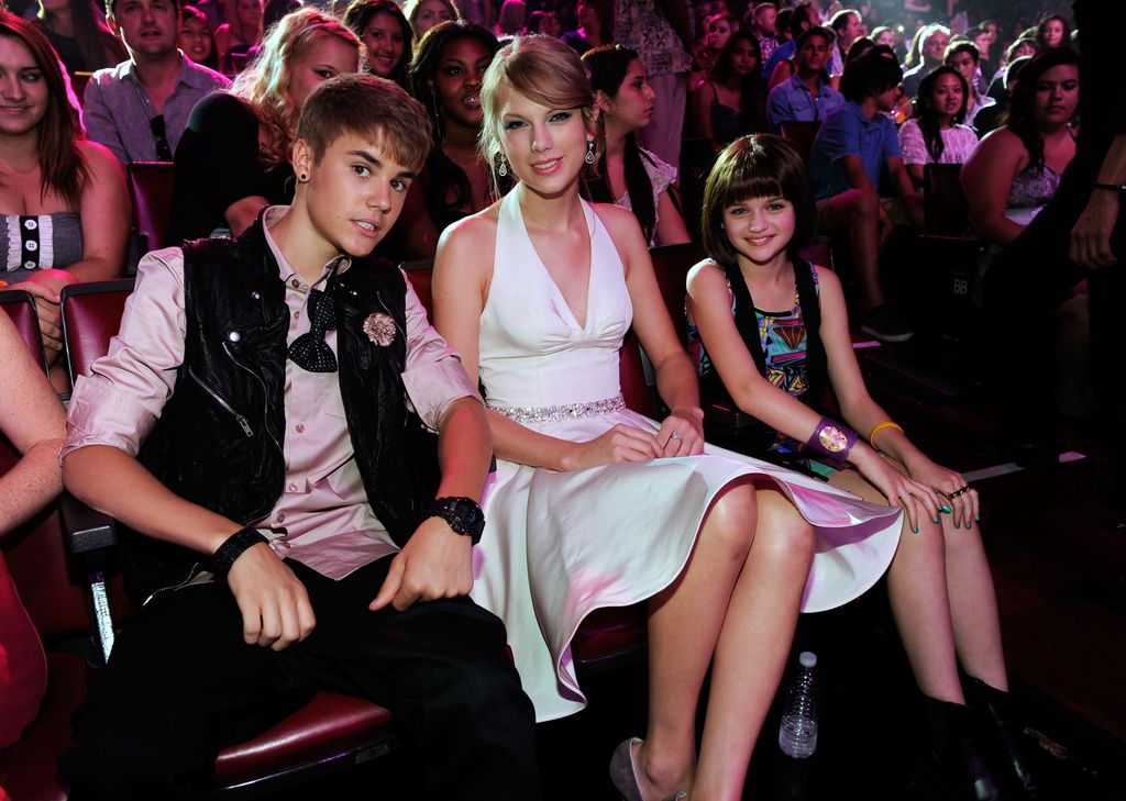 Justin Bieber, Taylor Swift and Joey King sit together in the audience at the 2011 Teen Choice Awards.