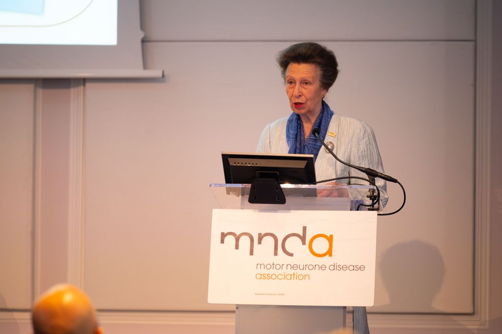 Princess Anne standing at a lectern in a blue suit