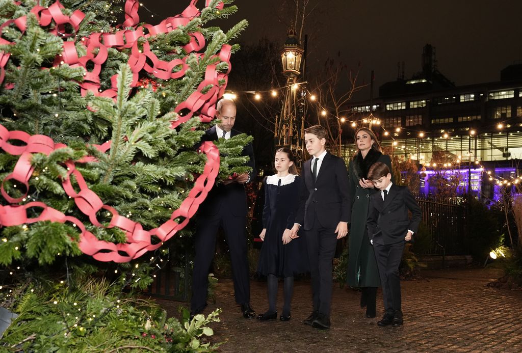 Prince William, Princess Charlotte, Prince George, Prince Louis and Kate Middleton looking at a Kindness tree