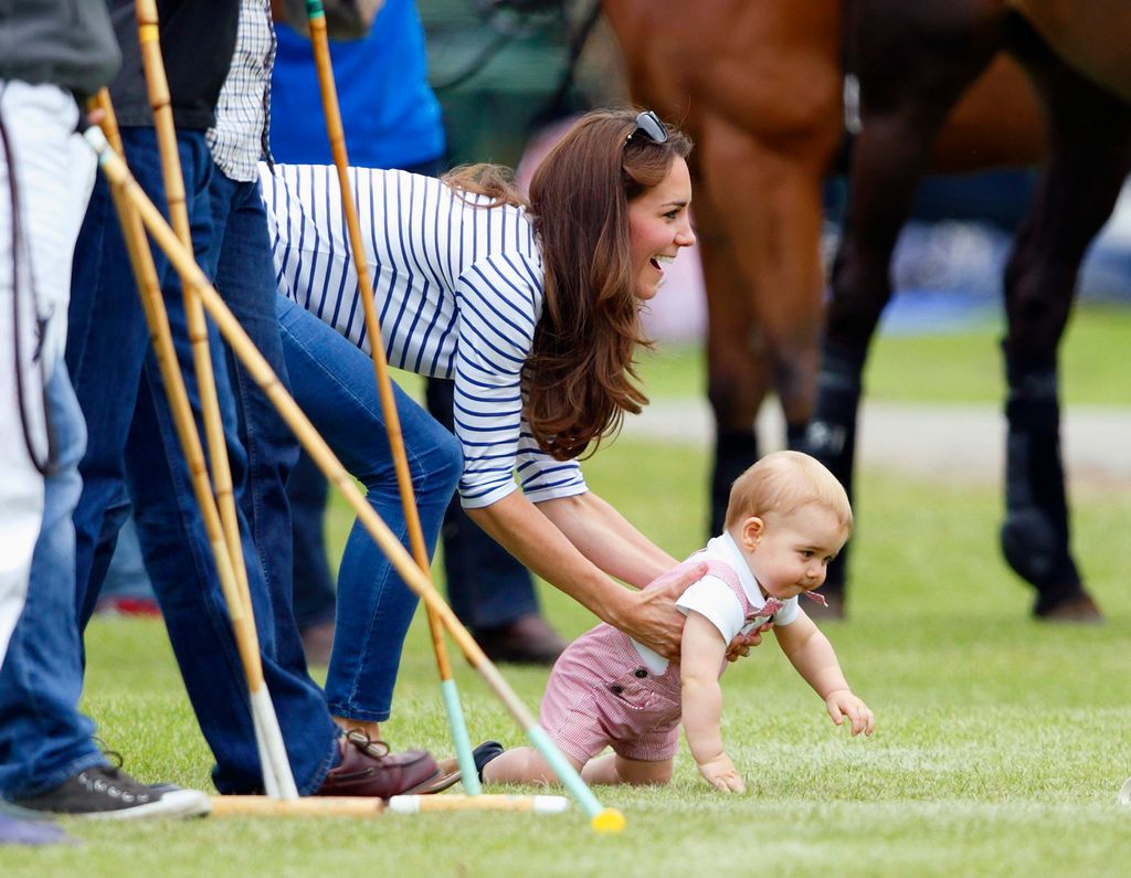 Prince George crawls at the polo match while held by Kate Middleton