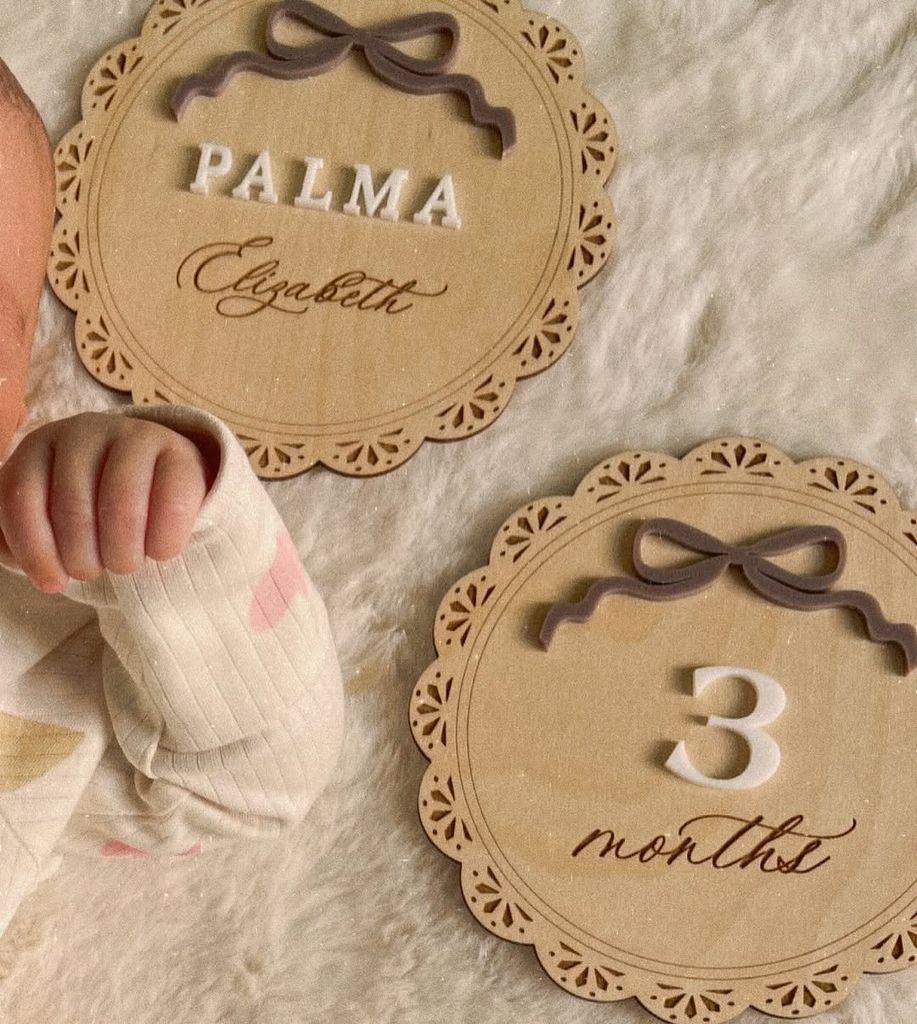 Baby Palma Michelle Keegan di Onesie Print Hati Di sebelah Papan Kayu Mengatakan 3 Bulan
