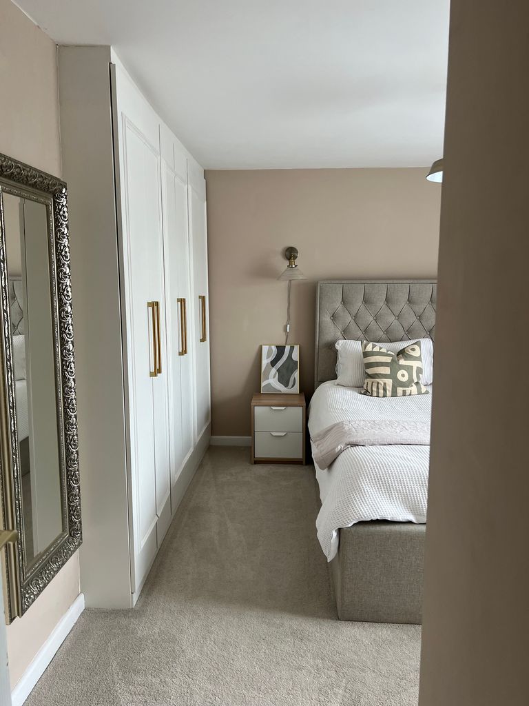 bedroom with wardrobes mirror and bed