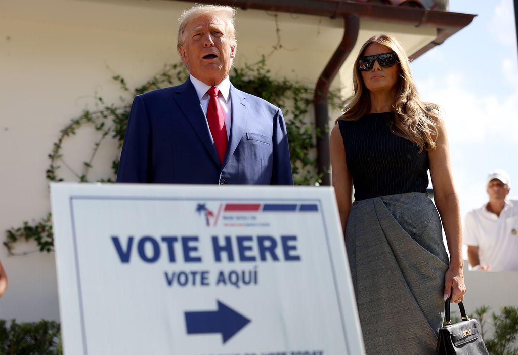 President Donald Trump stands with former first lady Melania Trump as he speaks to the media after voting in the 2022 midterms
