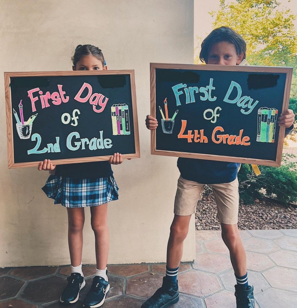 Photo shared by Daniela Ruah on Instagram September 2023 of her kids Sierra and River holding up signs marking their first day back at school.