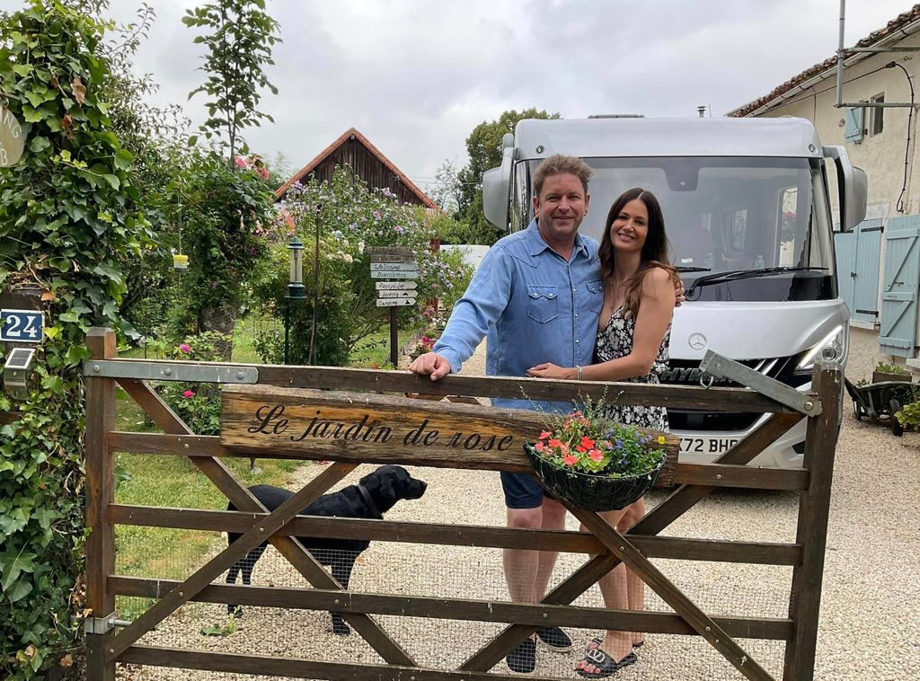 James Martin and girlfriend standing behind a gate in France