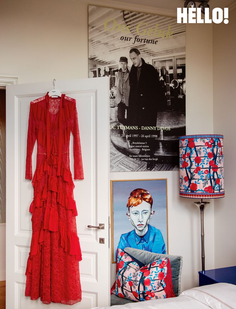 A red dress hanging from a door in a room with art on the wall in the three-storey apartment in Antwerp’s Graanmarkt Square