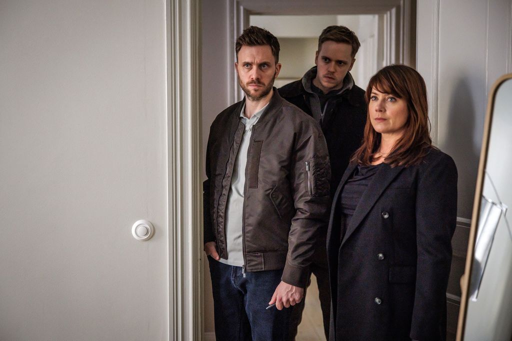 three people standing in house