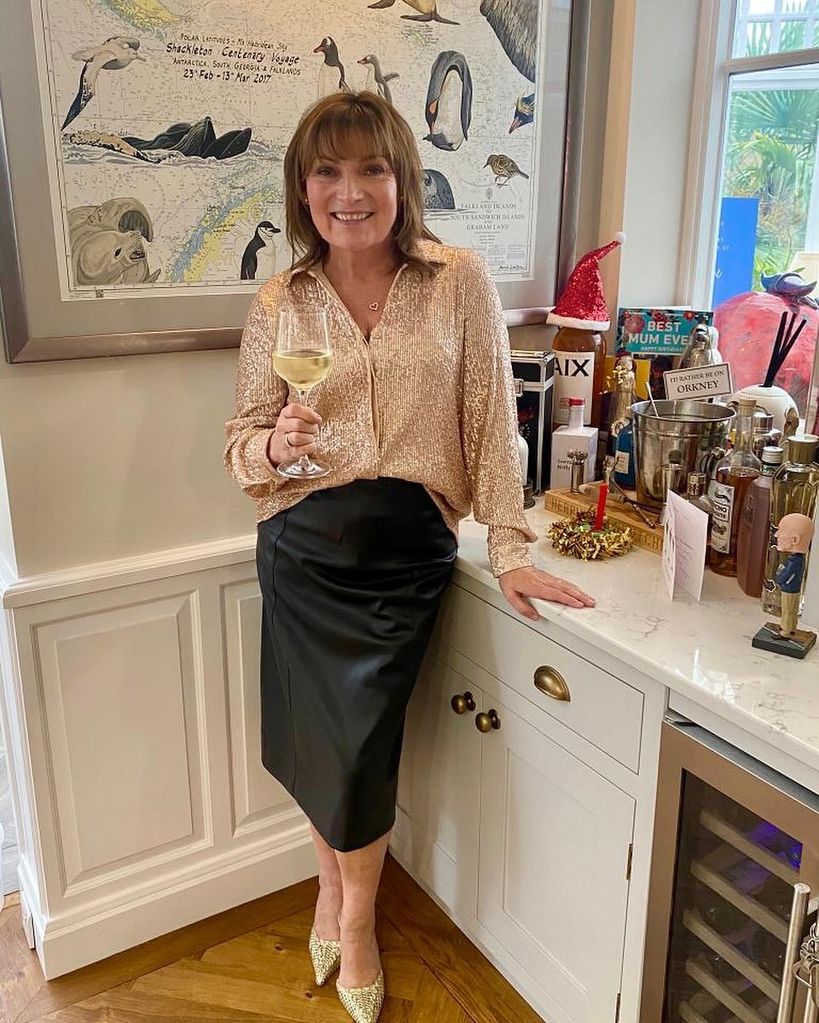 Lorraine standing with glass of wine in her kitchen