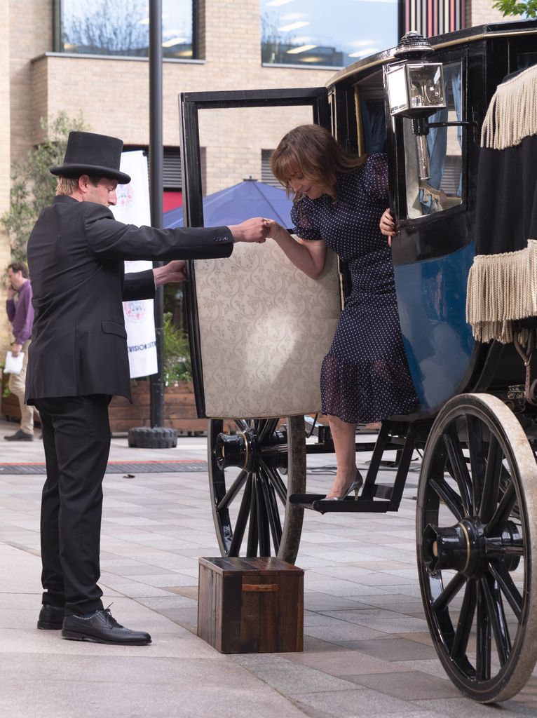 Lorraine Kelly is helped out of a horse and carriage