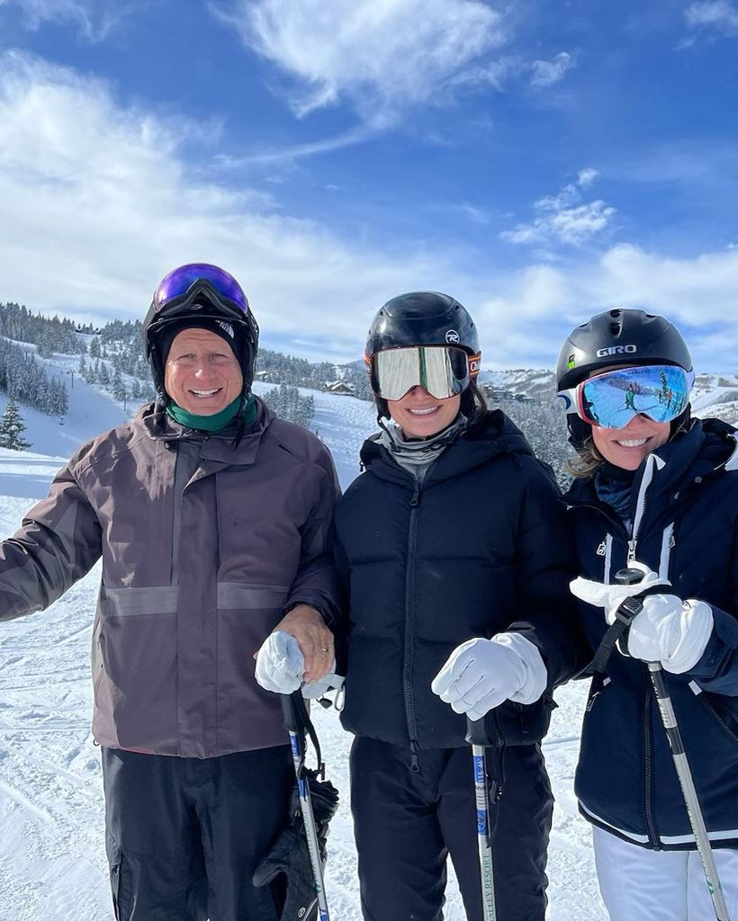 Jennifer, Tom and Chloe smiling in ski gear on a mountain