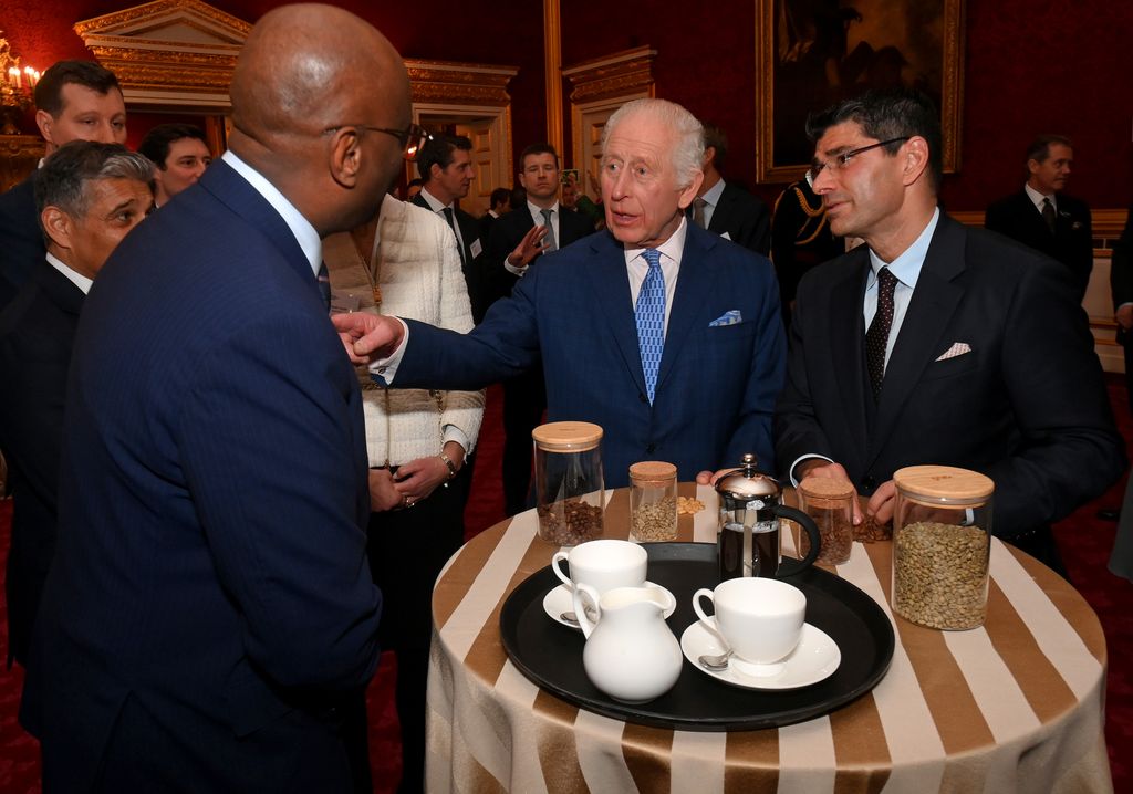 King Charles speaking with people in front of a table