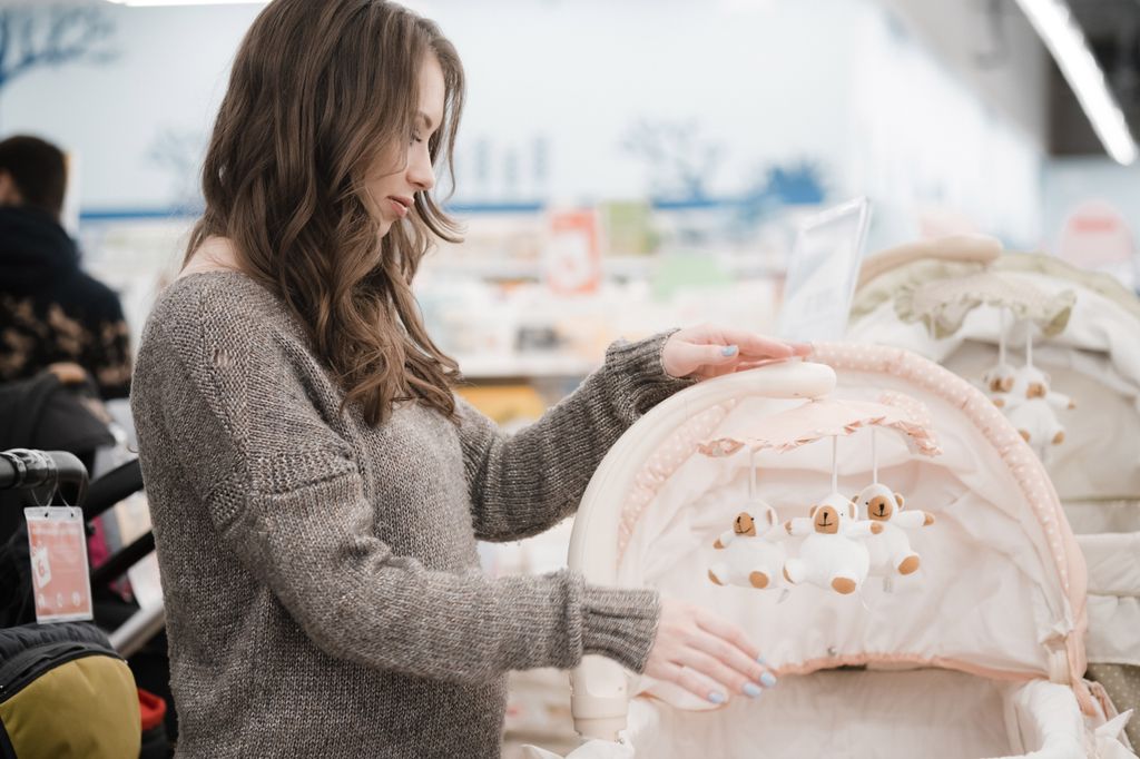 A pregnant woman looking at baby stuff