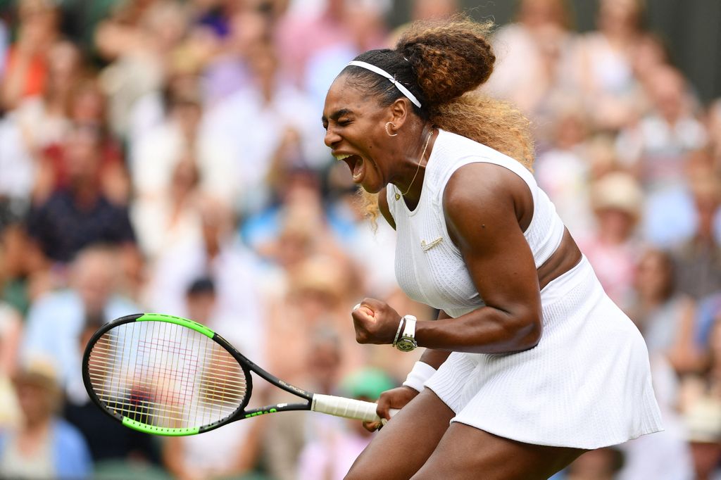 Serena Williams holds a racket and celebrates 