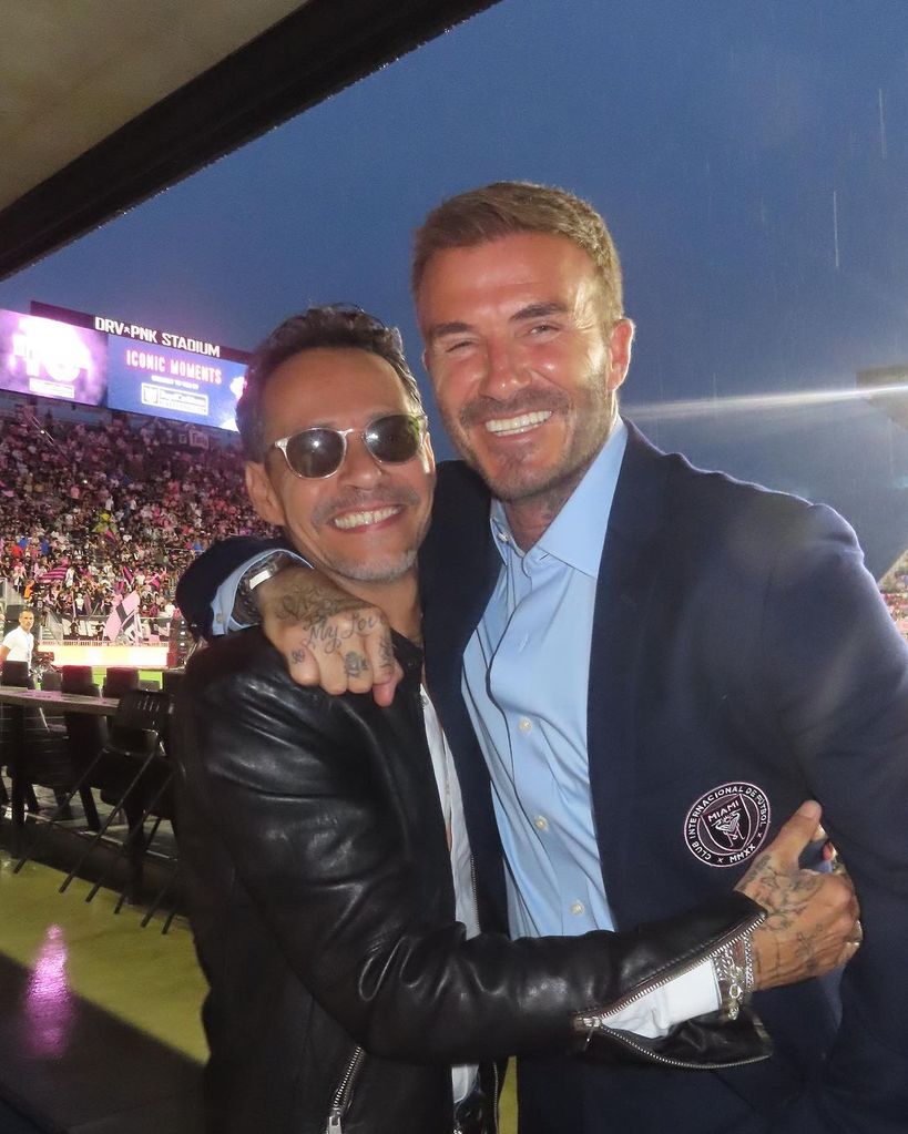 Marc Anthony and David Beckham smiling and hugging