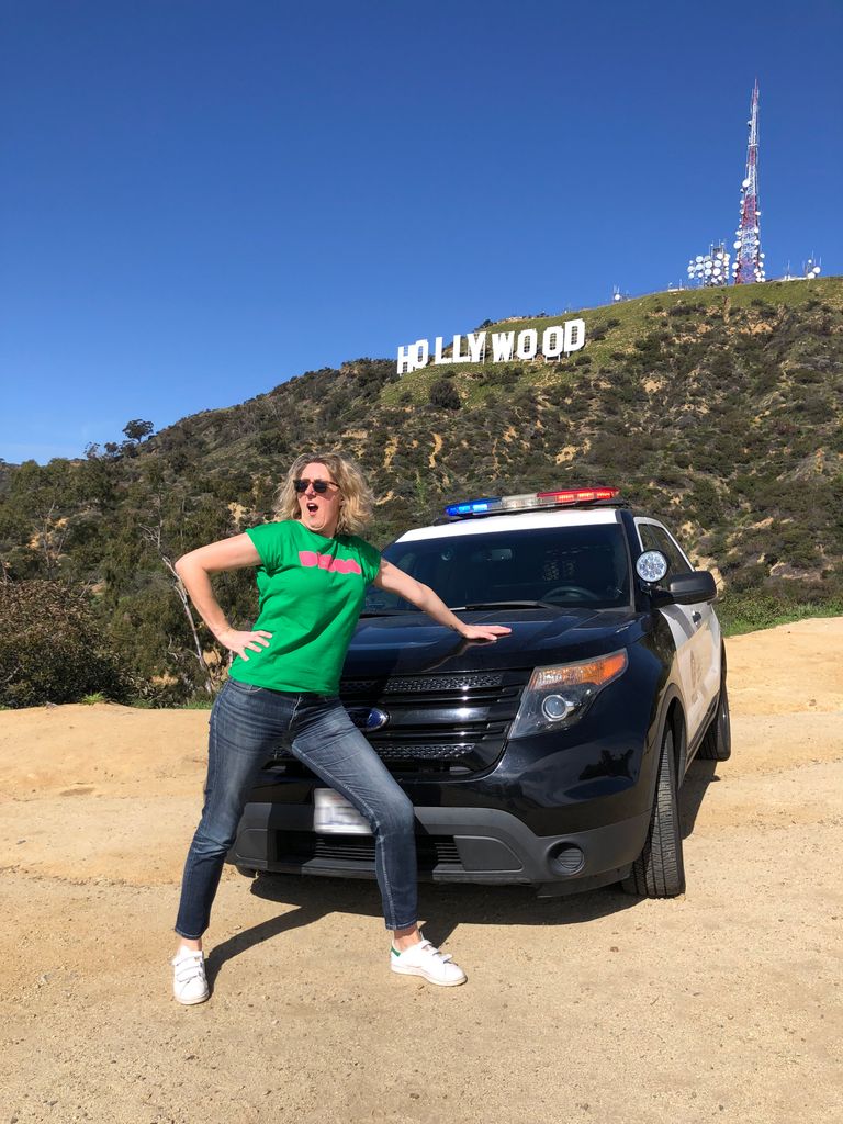 Travey Davies posing in front of a police car in Hollywood
