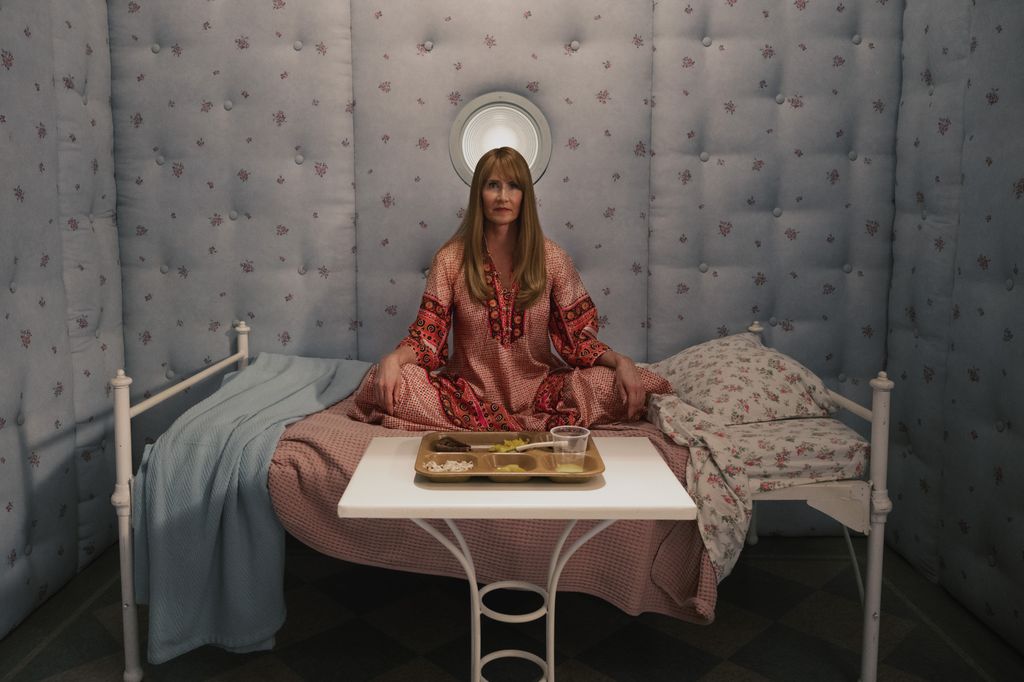 A woman sits cross-legged on a single bed