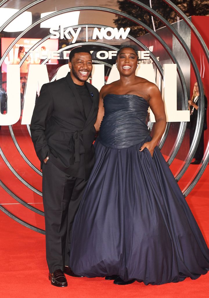 Lashana Lynch smiles with her husband on red carpet 