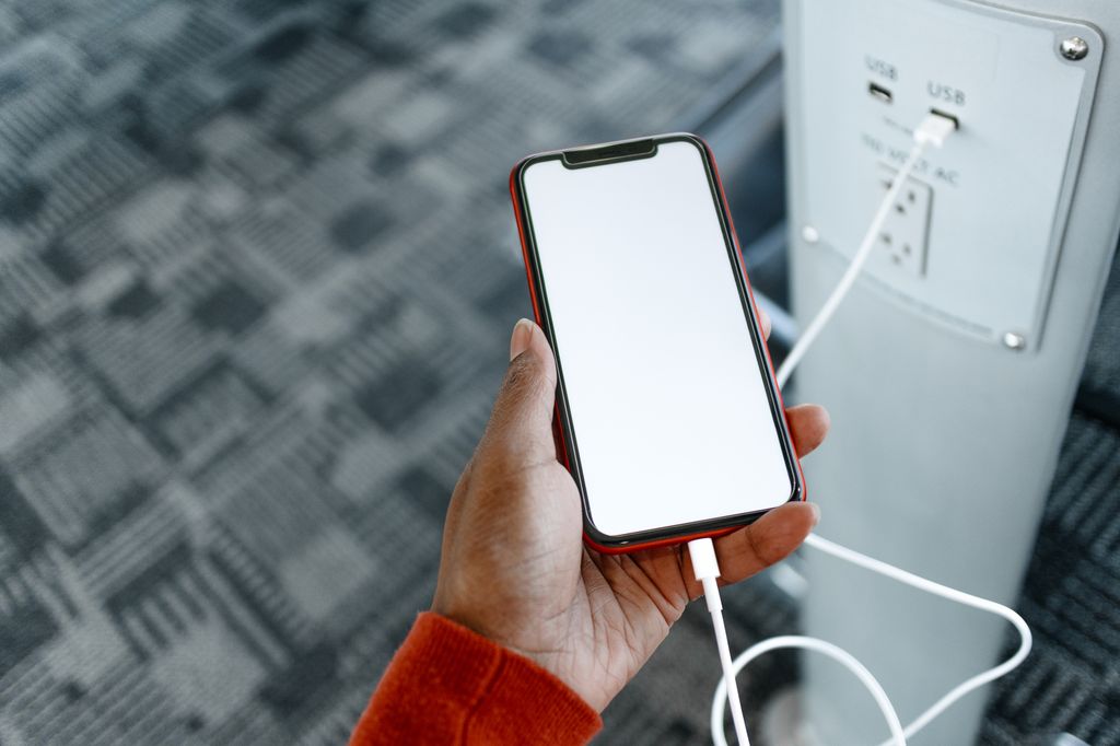 Close-up of unrecognizable black woman charging her smart phone at airport