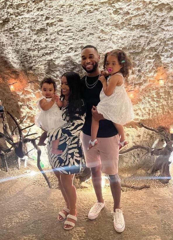 Tye White and wife Rania pose in a cave with their daughters