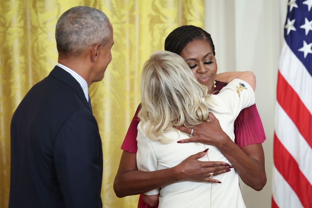 The first lady Jill hugs former first lady Michelle Obama during a ceremony to unveil their official White House portraits