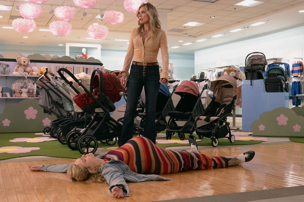 woman lying on floor in clothing store, older woman standing over her