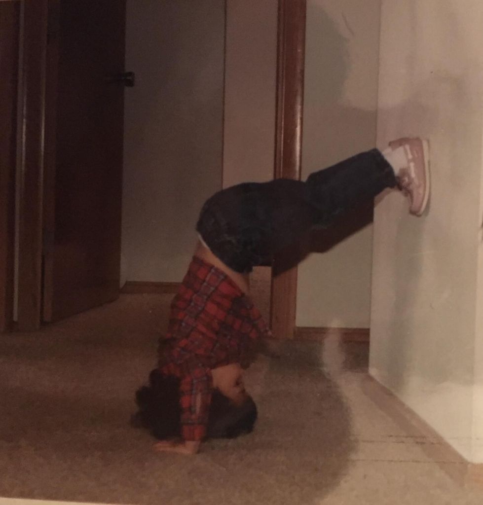 photo of daniela ruah aged 2 performing handstand against a wall