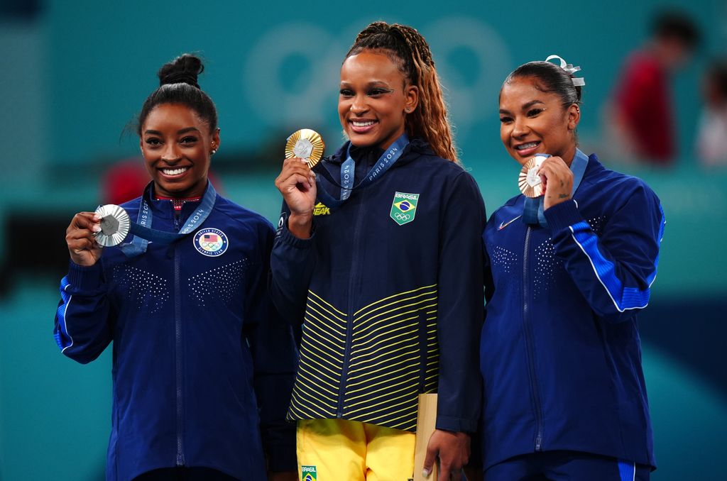 Gold medalist Rebeca Andrade (centre) of Brazil, silver medalist Simone Biles (left) of the USA and bronze medalist Jordan Chiles (right) of the USA following the Women's Floor Exercise Final at the Bercy Arena on the tenth day of the 2024 Paris Olympic Games in France