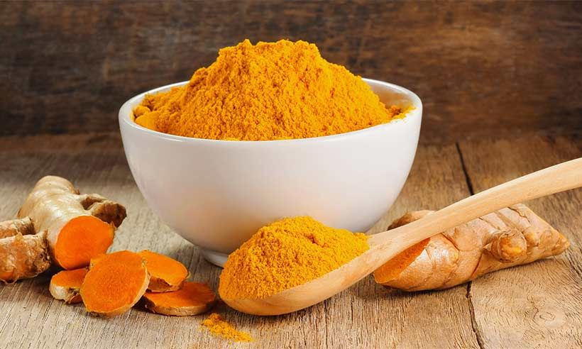 bowl of turmeric with a spoon next to it 