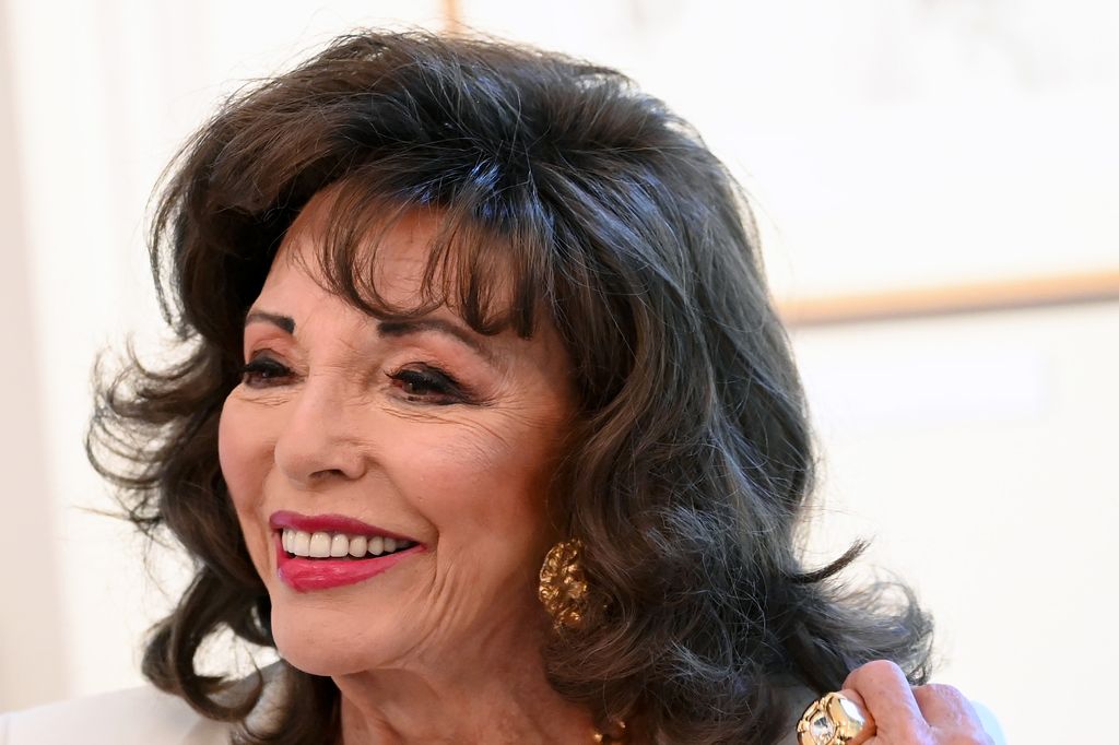 Joan Collins smiles at event