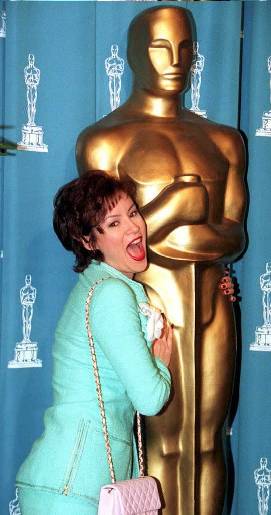 Jennifer Tilly, Academy Awards Nominee for best performance by an actress in a supporting role in "Bullets Over Broadway," hugs an Oscar statue during Academy Awards Luncheon14 March at the Beverly Hills Hilton, 1994
