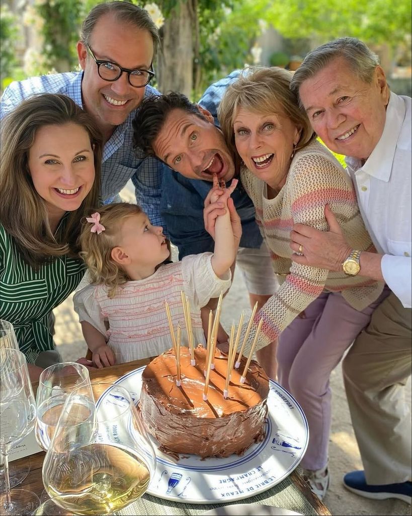 Ryan Seacrest (3L) pretends to bite his nieces fingers as he stands with his family including father Gary (R)