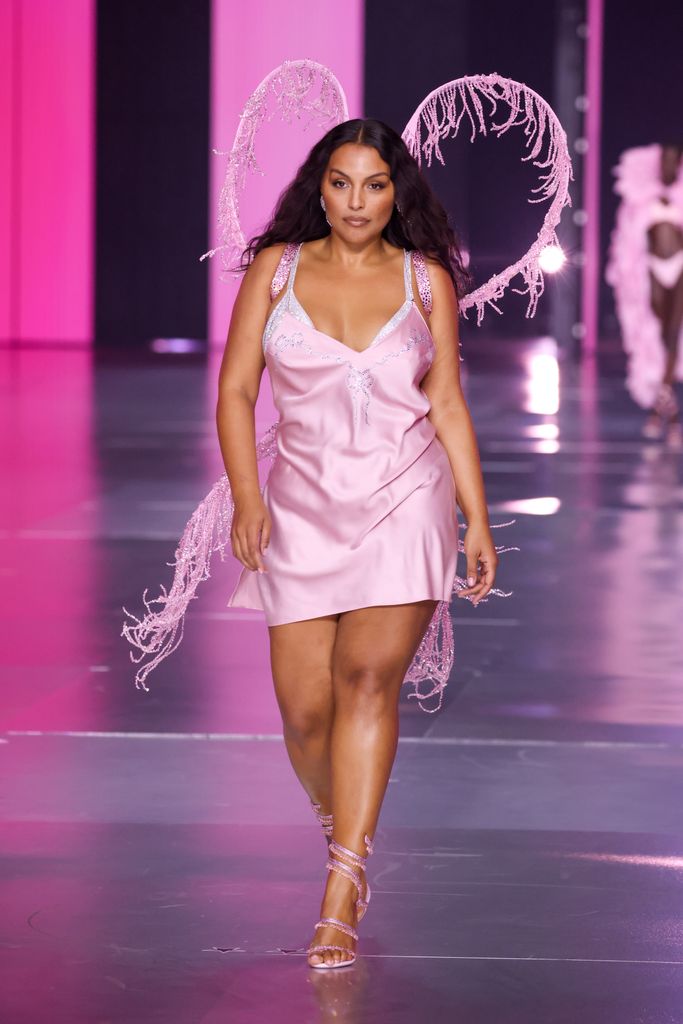 Paloma Elsesser walks the 2024 Victoria's Secret Fashion Show runway in a pink mini dress with glittery heart wings.