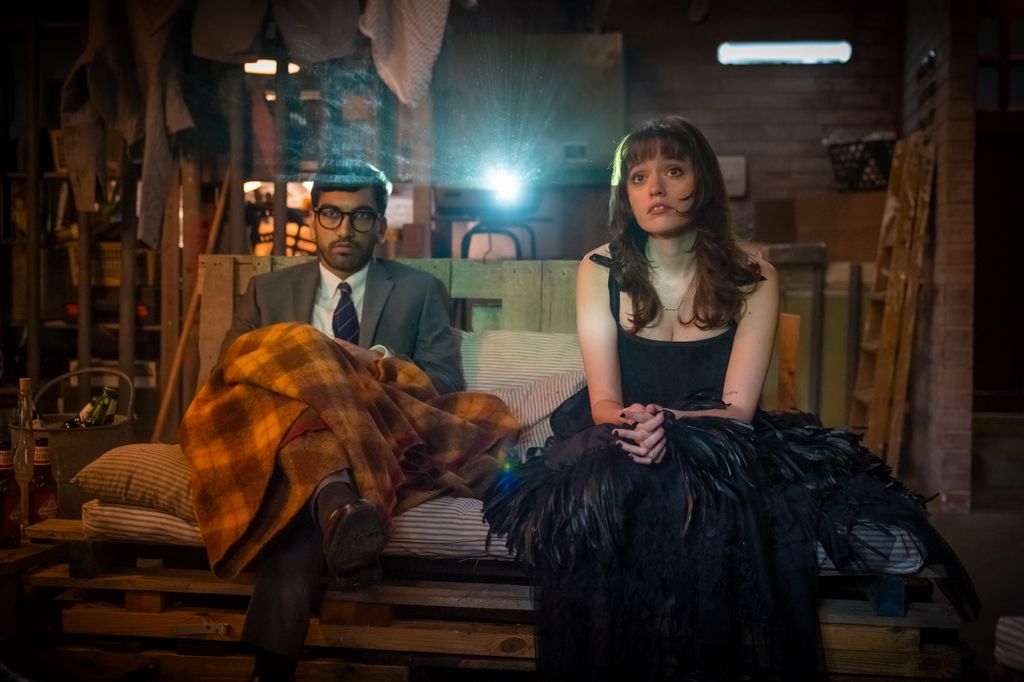 young and and woman sitting on sofa watching screen