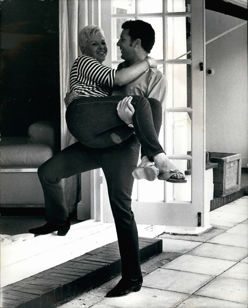 Tom Jones carrying wife Linda into their home