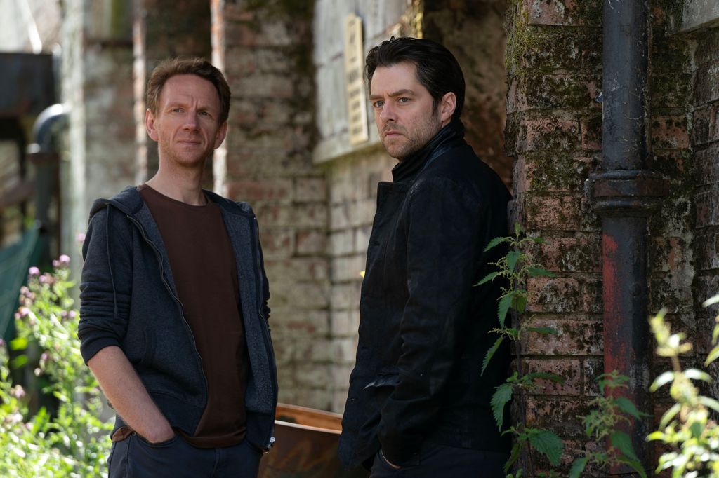 two men standing outside building