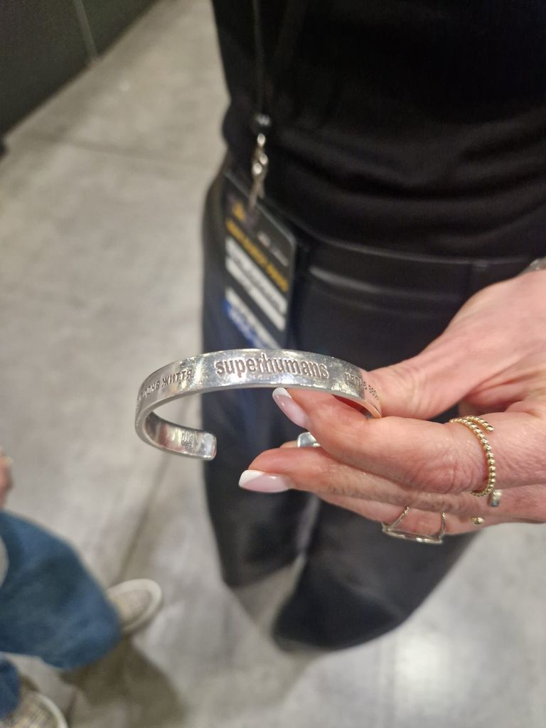 Superhumans bracelet worn by Olga Rudnieva that is the same one gifted to Prince Harry