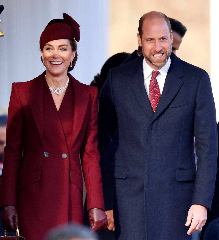 Kate Middleton in red outfit and Prince William in a blue suit