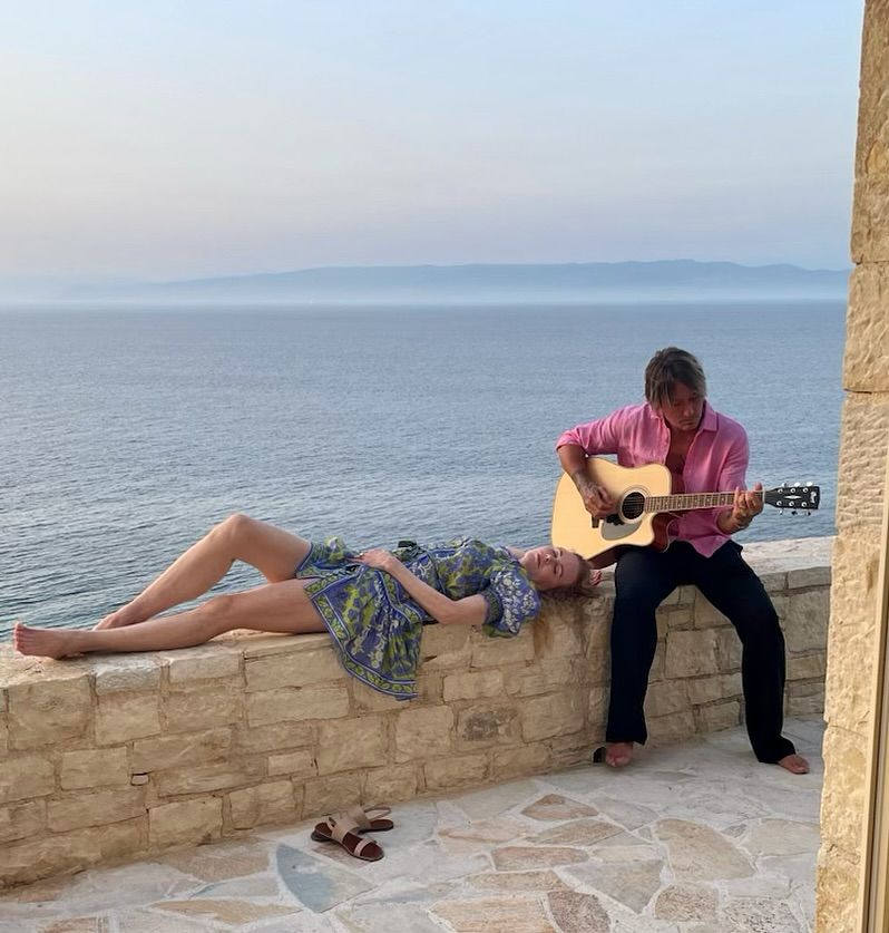 Nicole Kidman lying on wall next to guitar playing husband Keith Urban