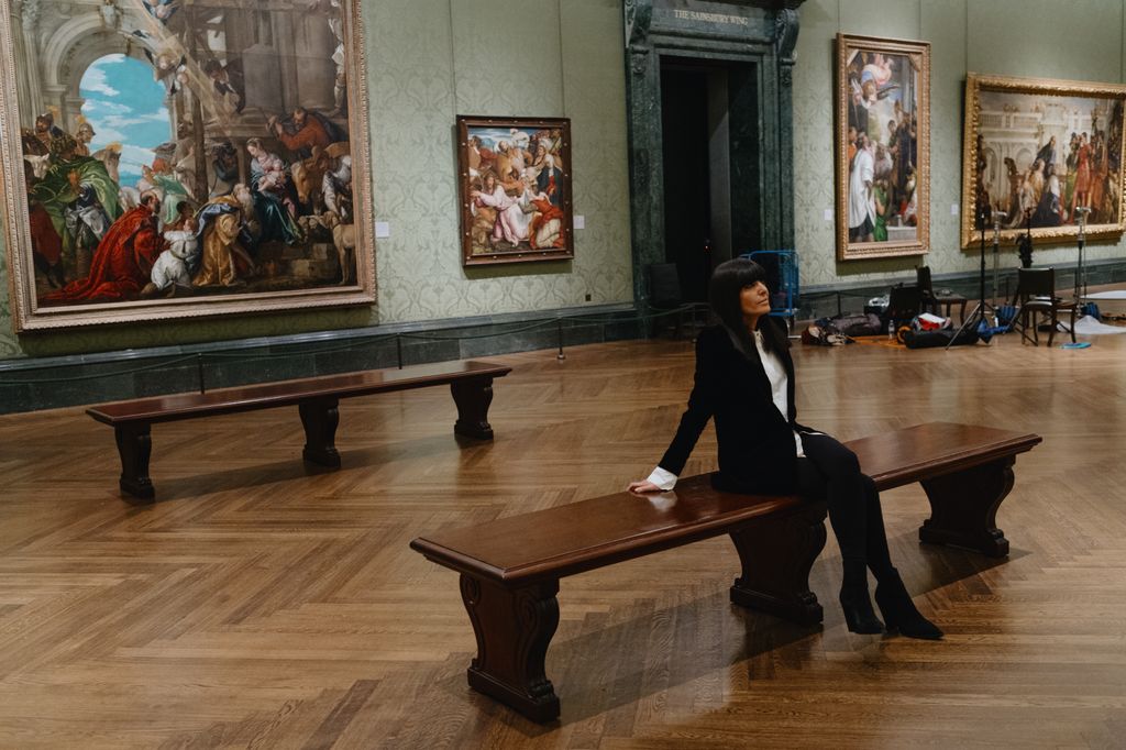 woman looking at painting on wooden bench